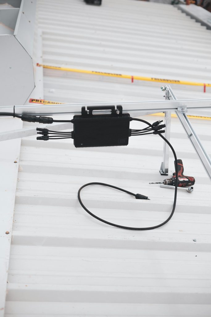 pexels-photo-8853468-8853468 Close-up of solar charge controller installation with cables on a metal roof.